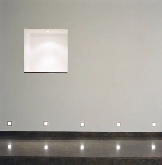 Interior de una vivienda proyectada por Manuel Baró, arquitecto en Granollers: pared blanca con hornacina iluminada y luces empotradas