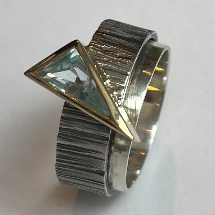 Anillo de plata texturada con piedra azul triangular, joyería artesanal de Manuel Baró
